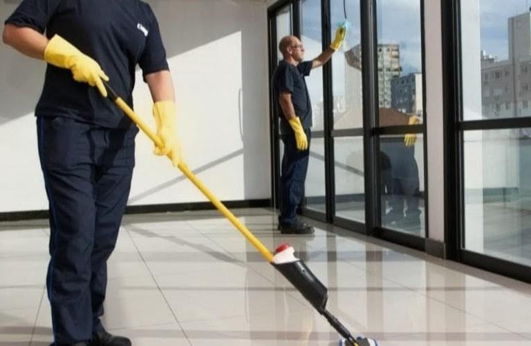 Profissionais realizando a limpeza de pisos e vidros